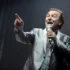 Karel Gott zpívá s mikrofonem v ruce.