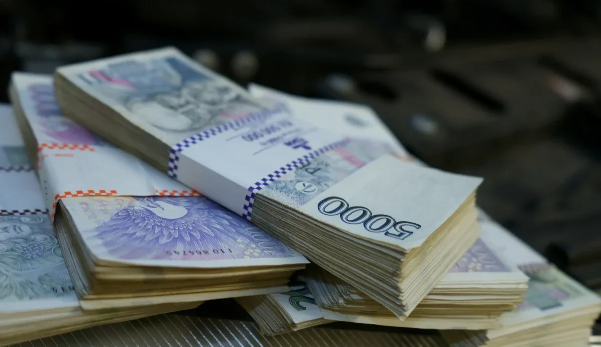 Stacks of banknotes arranged on a surface, primarily 1,000-denomination bills with purple highlights.