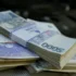 Stacks of banknotes arranged on a surface, primarily 1,000-denomination bills with purple highlights.