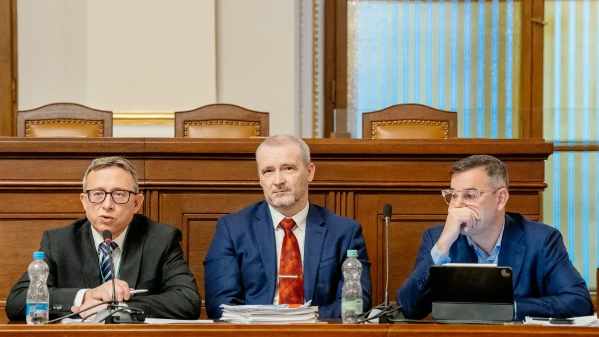 Mojmír Hampl sedí vedle dvou mužů.