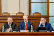 Mojmír Hampl sedí vedle dvou mužů.