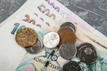 Na sobě leží kupička peněz.