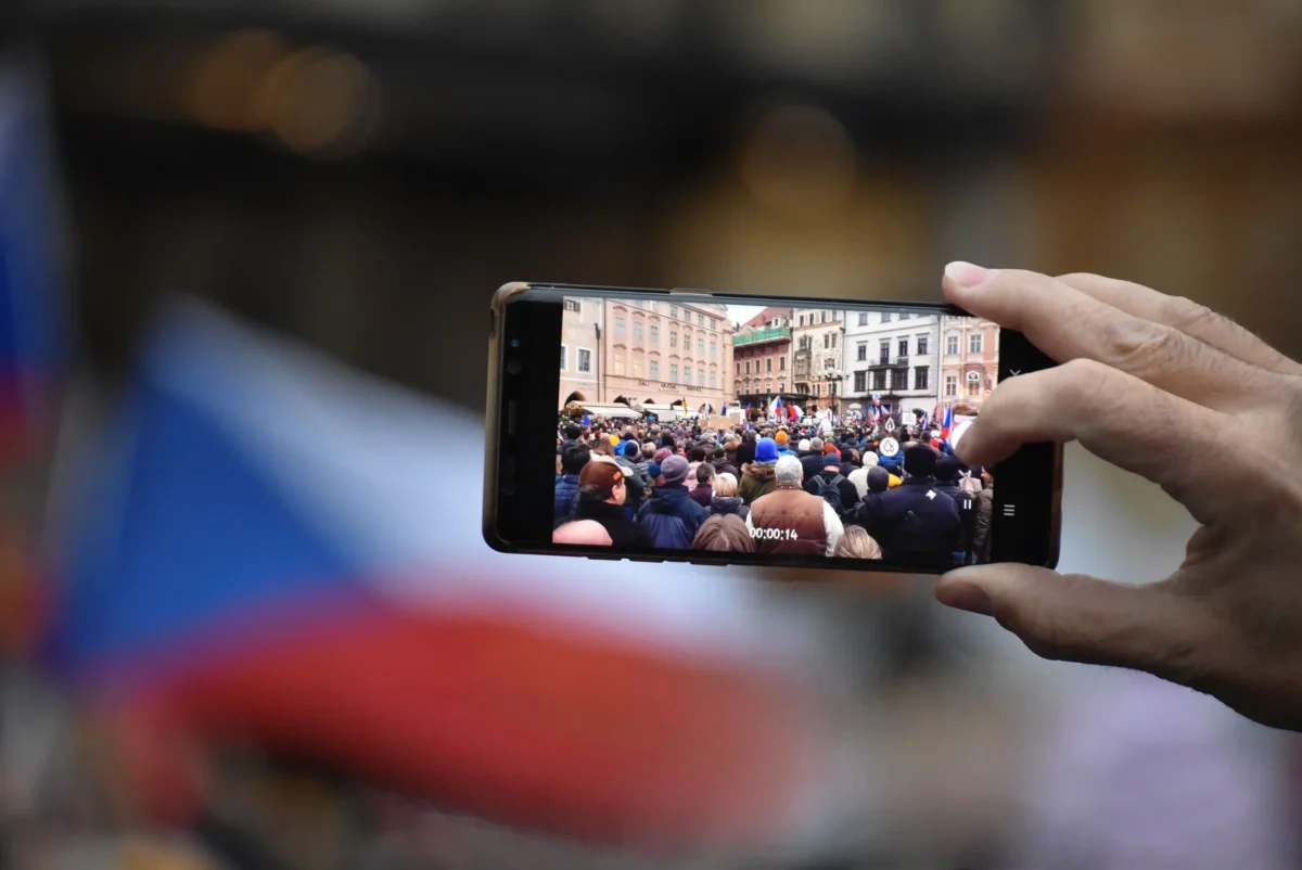 shutterstock_2098802557 | TVGURU.cz Člověk natáčí na mobil protest.