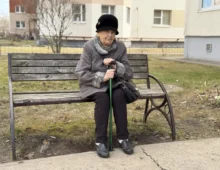Babička sedí na lavičce.