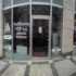Front of Pojišťovna VZP a.s. branch with curved glass doors and MUZEUM signage on the windows