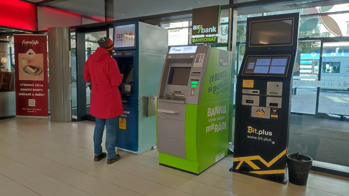 Žena stojí u bankomatu.