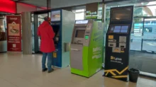 Žena stojí u bankomatu.
