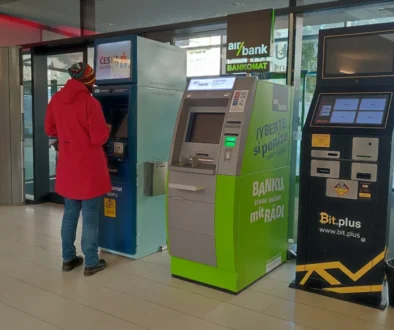 Žena stojí u bankomatu.