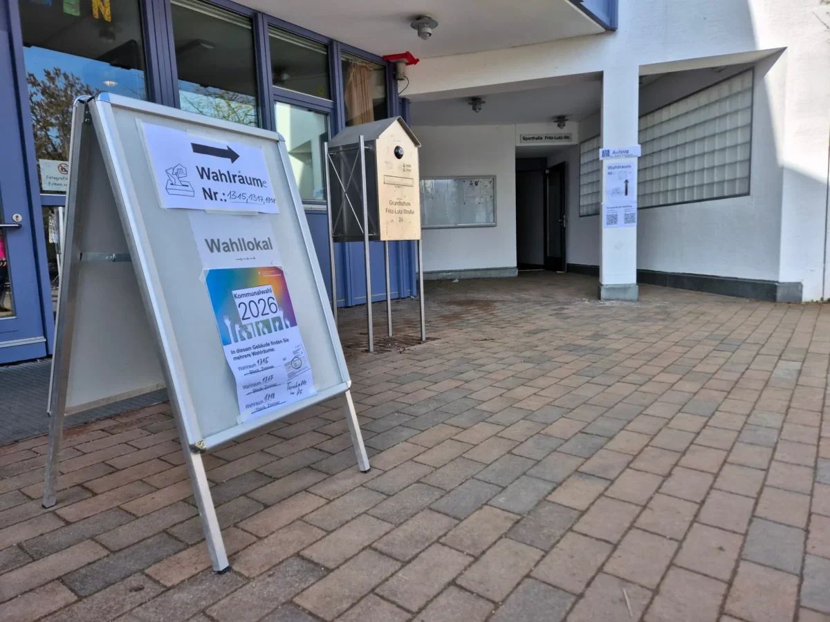 A freestanding election sign outside a building pointing voters to polling rooms (Wahlräume).