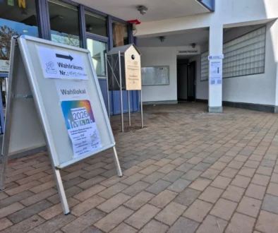 A freestanding election sign outside a building pointing voters to polling rooms (Wahlräume).