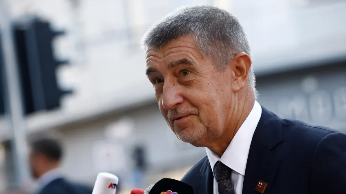 Andrej Babiš stojí u mikrofonu.