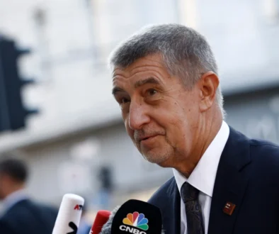 Andrej Babiš stojí u mikrofonu.