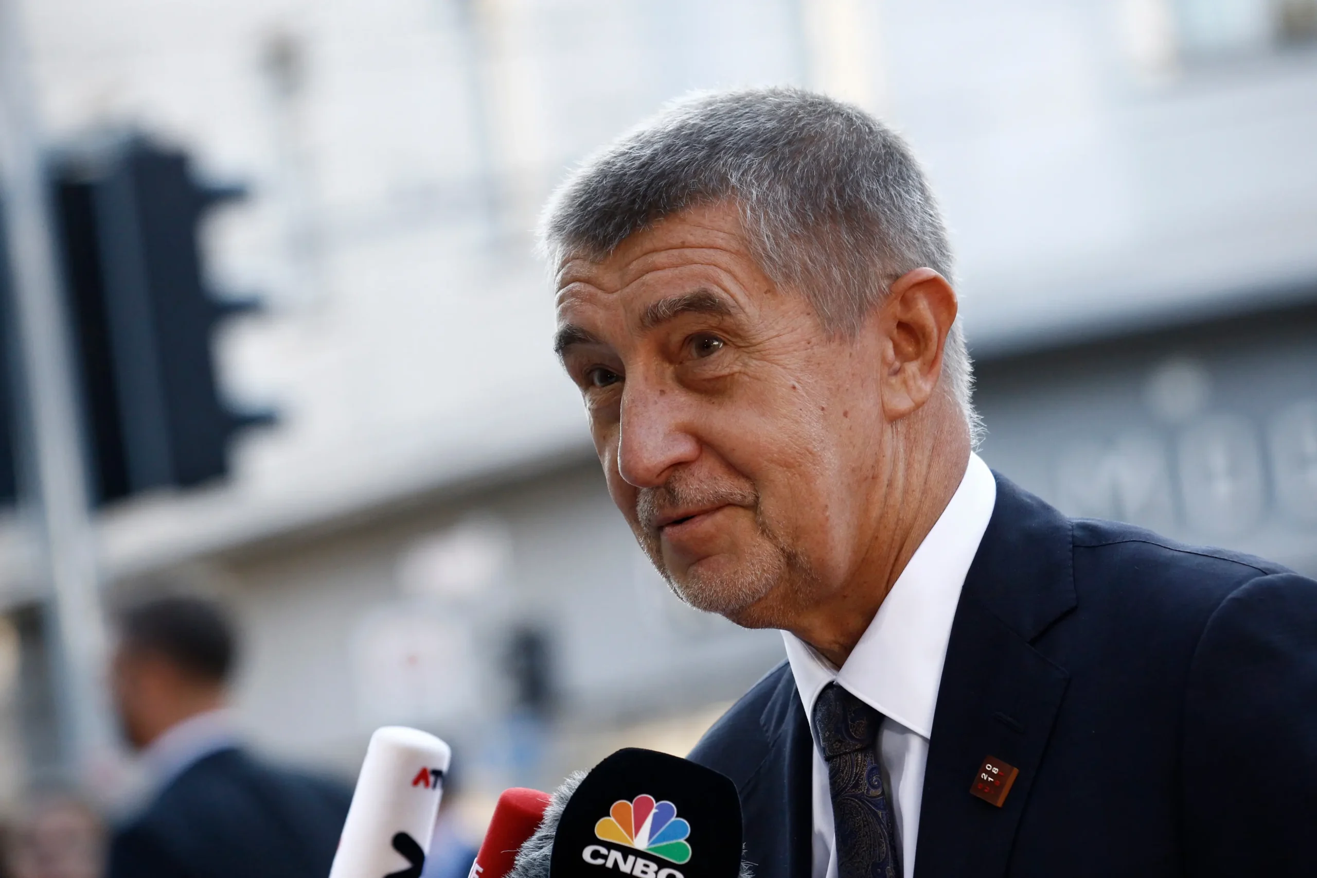 Andrej Babiš stojí u mikrofonu.