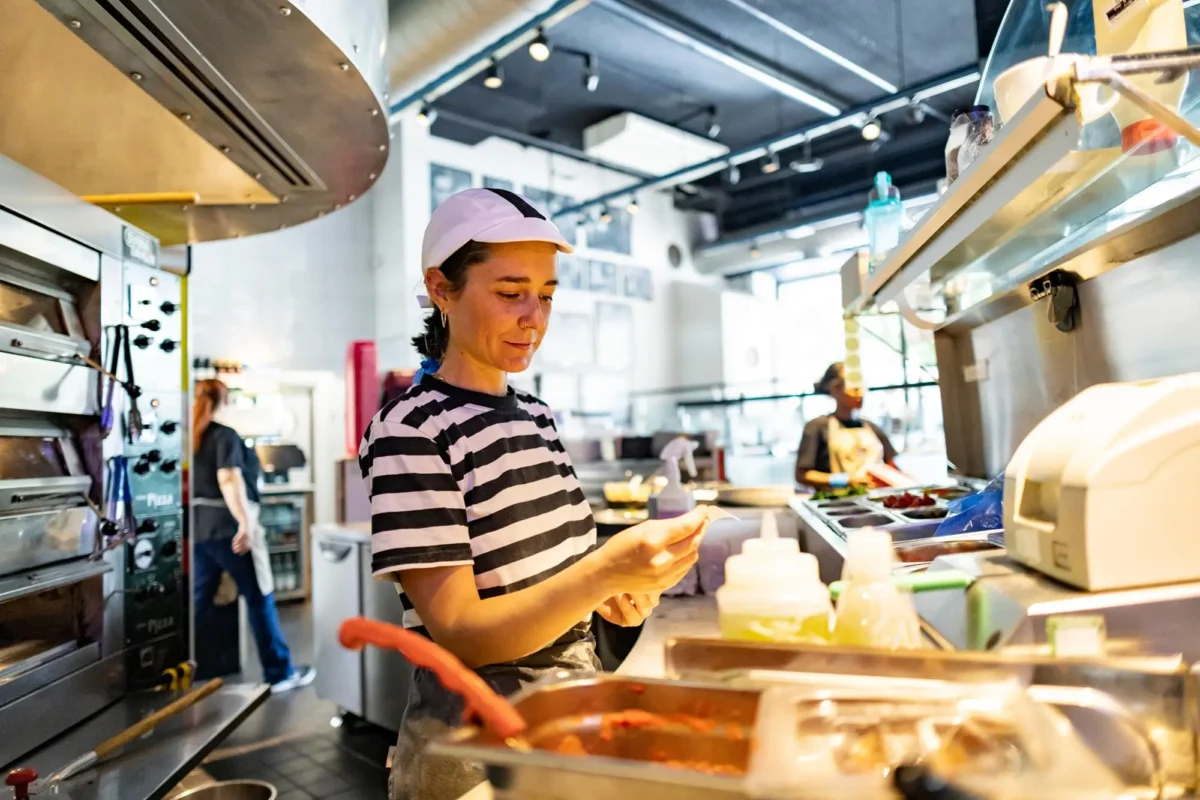 shutterstock_2563124255 1 | TVGURU.cz dívka pracuje ve fast foodu