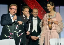 Václav Kopta s mikrofonem stojí vedle tří lidí.