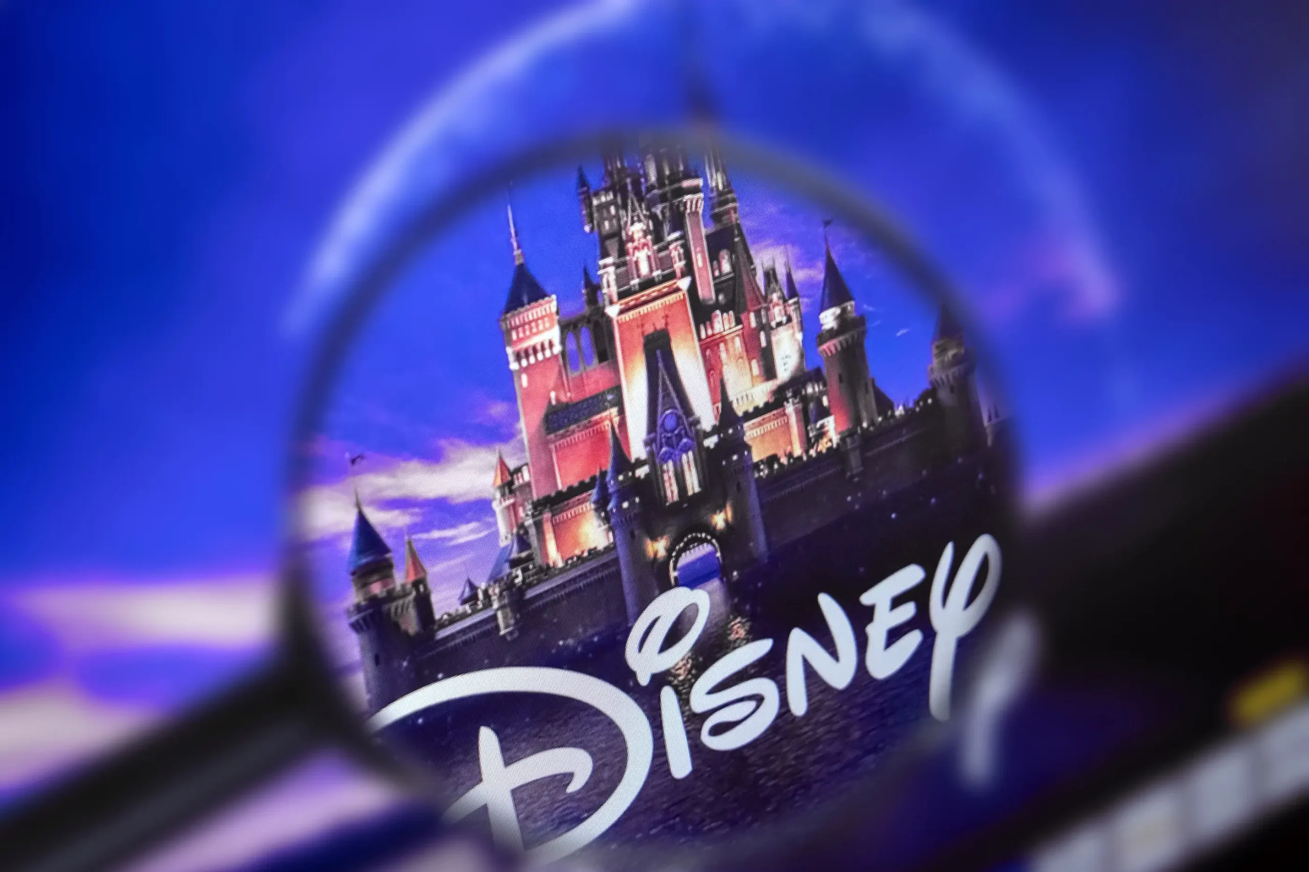 Lupa přibližuje logo Disney.