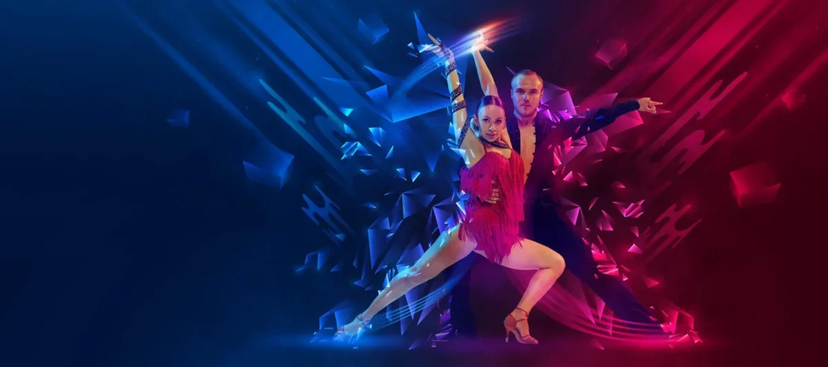 Duo of ballroom dancers mid-leap on a neon-lit stage, woman in a pink fringe dress and man in dark attire, with blue and magenta geometric light effects.