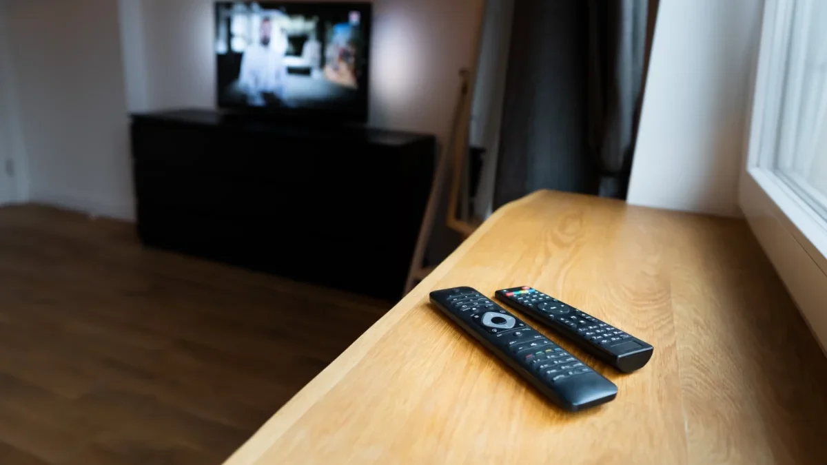 Na parapetu leží ovladače od TV.