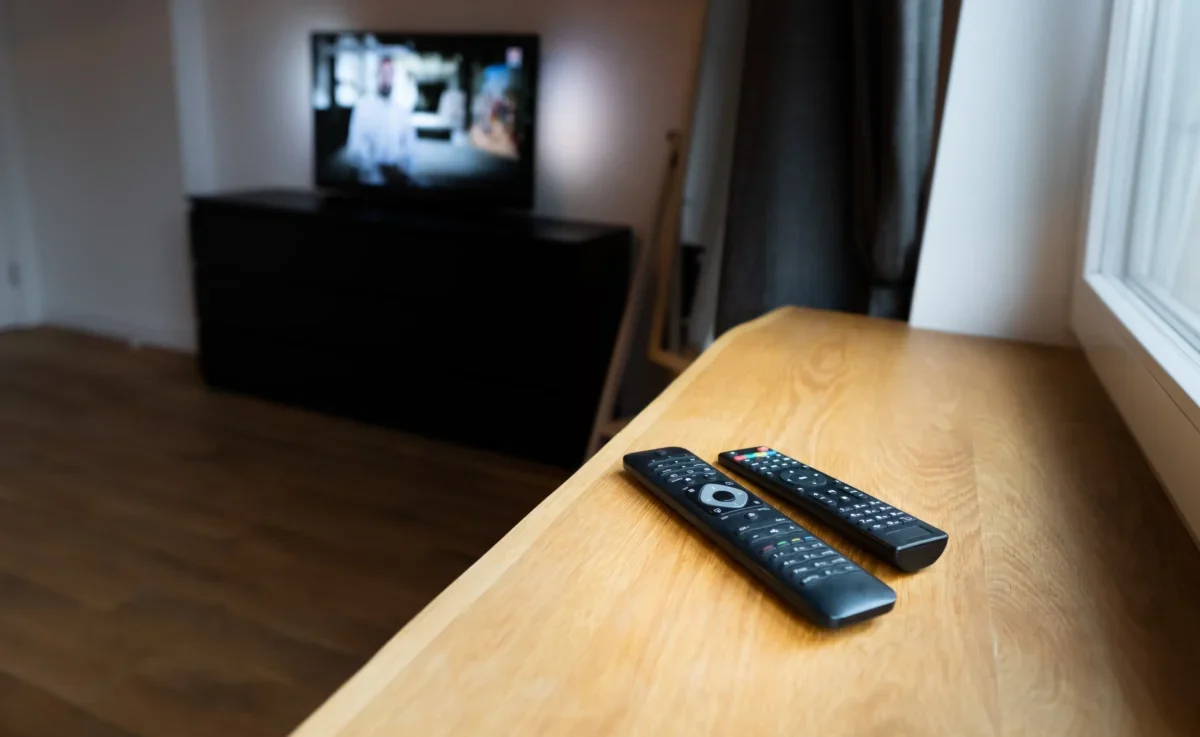 Na parapetu leží ovladače od TV.
