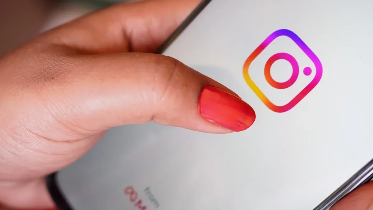 Žena prstem míří na ikonku Instagramu.