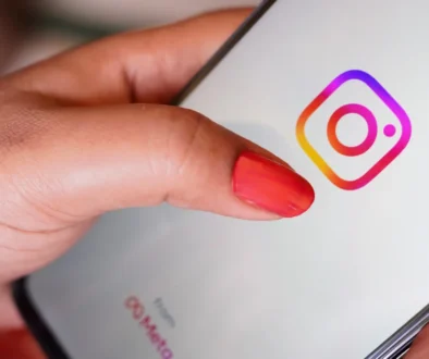 Žena prstem míří na ikonku Instagramu.