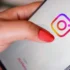 Žena prstem míří na ikonku Instagramu.