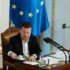 Muž v obleku a za ním vlajka Evropské unie.