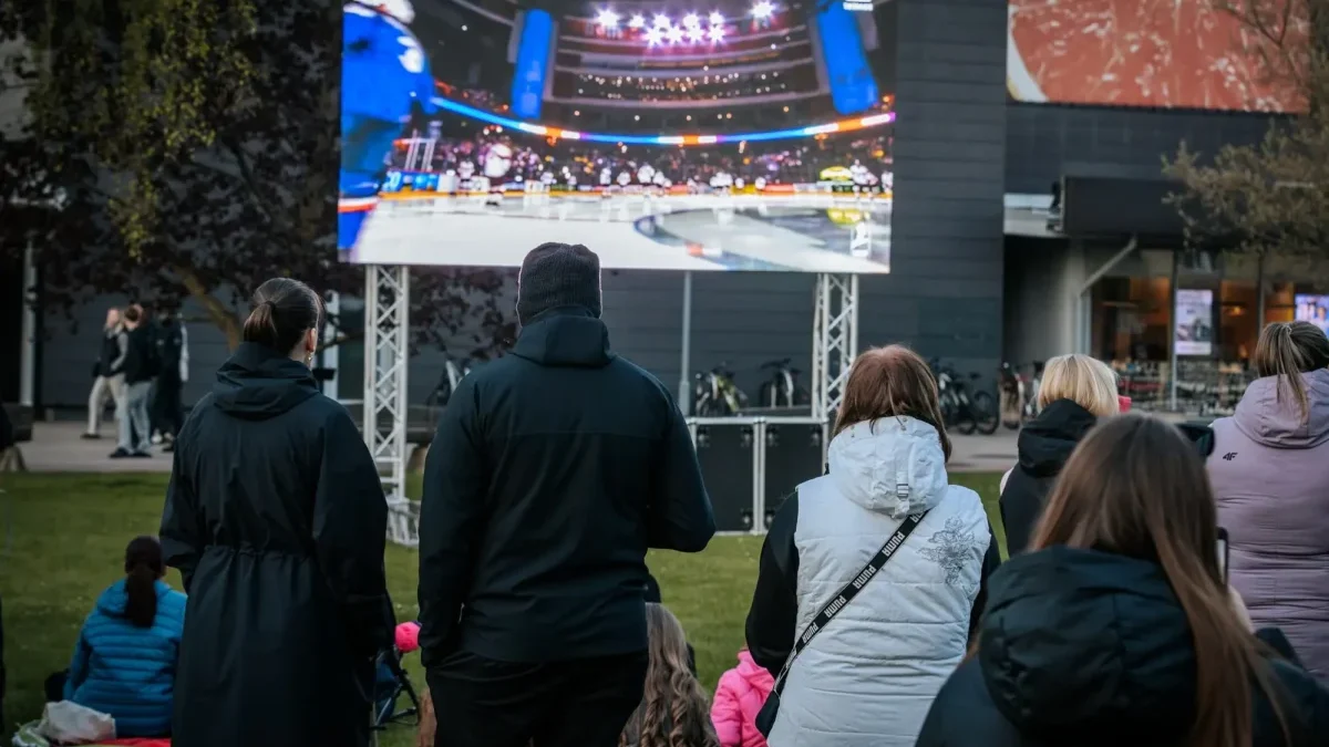 fanoušci sledují sportovní přenos venku
