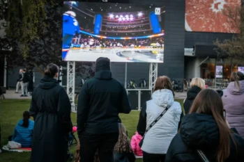 fanoušci sledují sportovní přenos venku