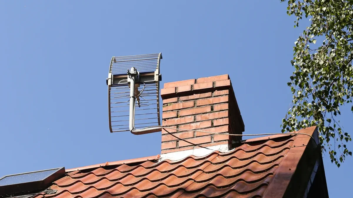 Na střeše za komínem je televizní anténa k chytání televizního signálu