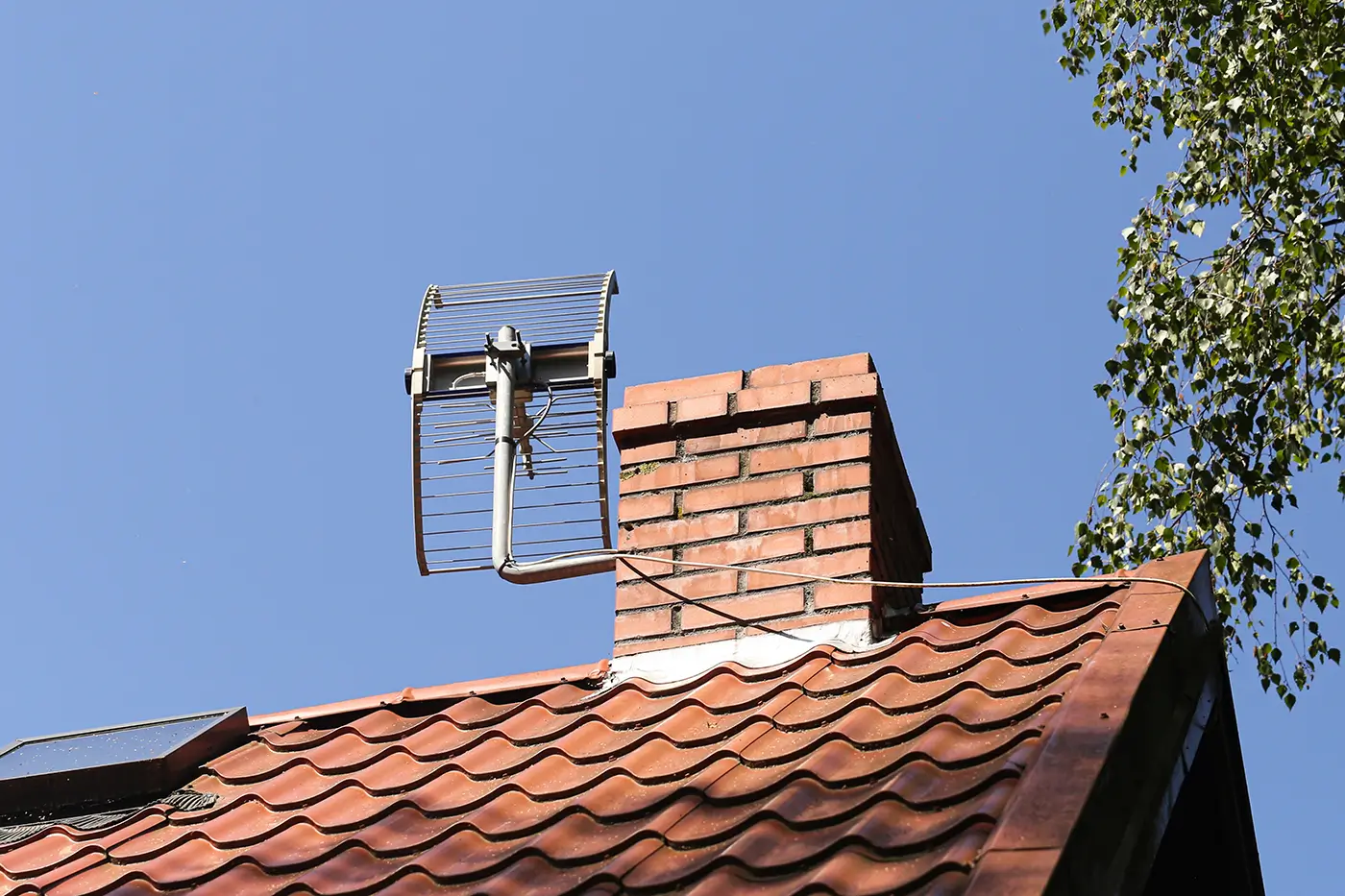 Na střeše za komínem je televizní anténa k chytání televizního signálu