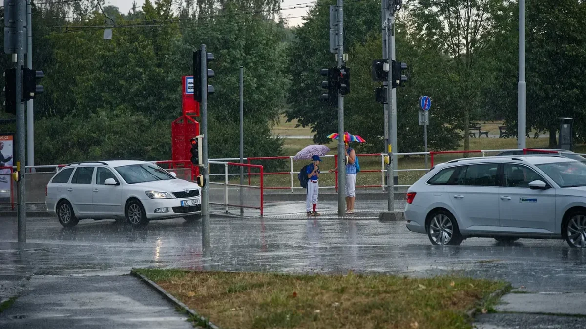 Deštivý den v hlavním městě České republiky a záběr na ulici s auty a lidmi s deštníky