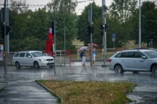 Deštivý den v hlavním městě České republiky a záběr na ulici s auty a lidmi s deštníky