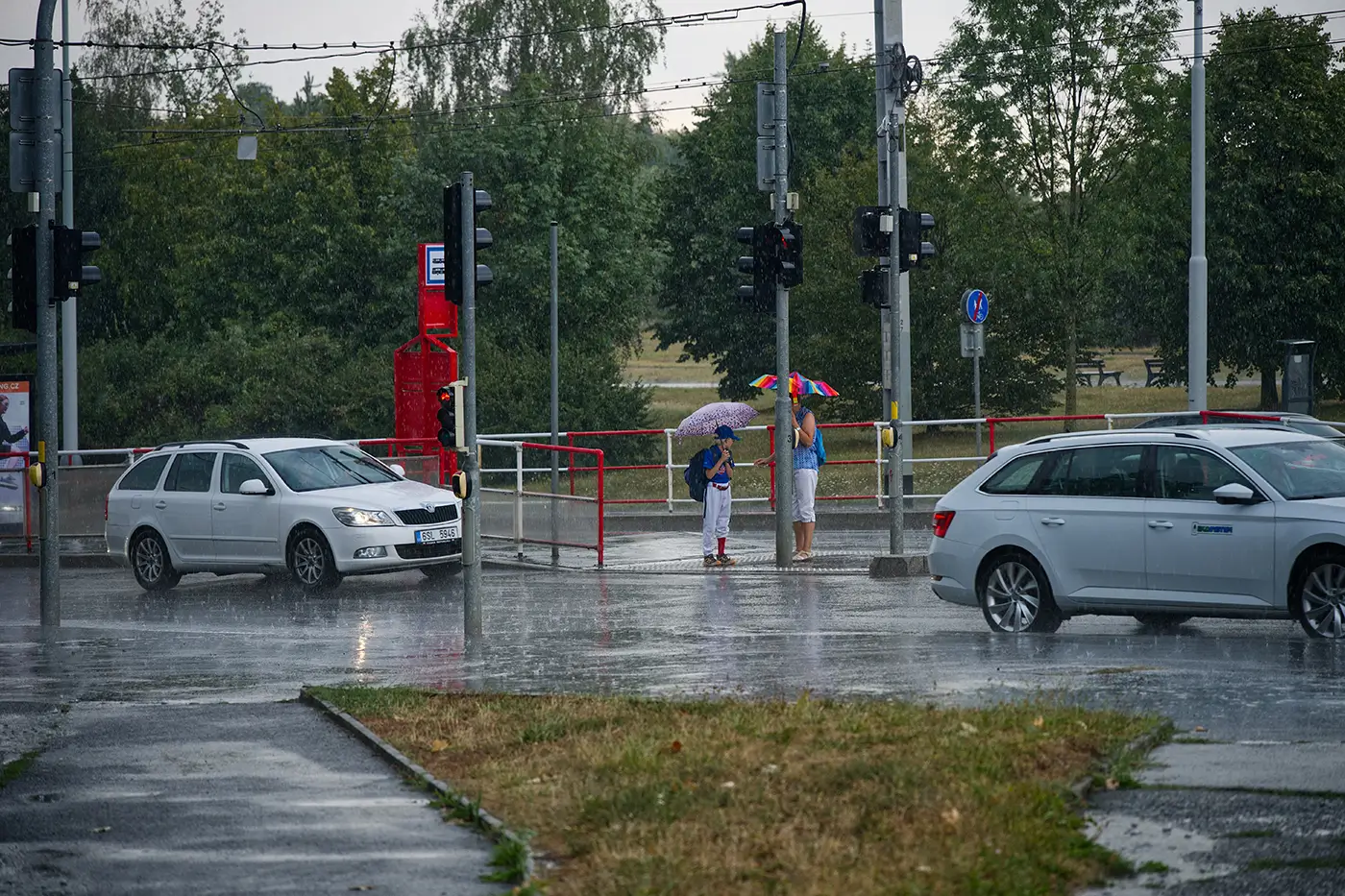 Deštivý den v hlavním městě České republiky a záběr na ulici s auty a lidmi s deštníky