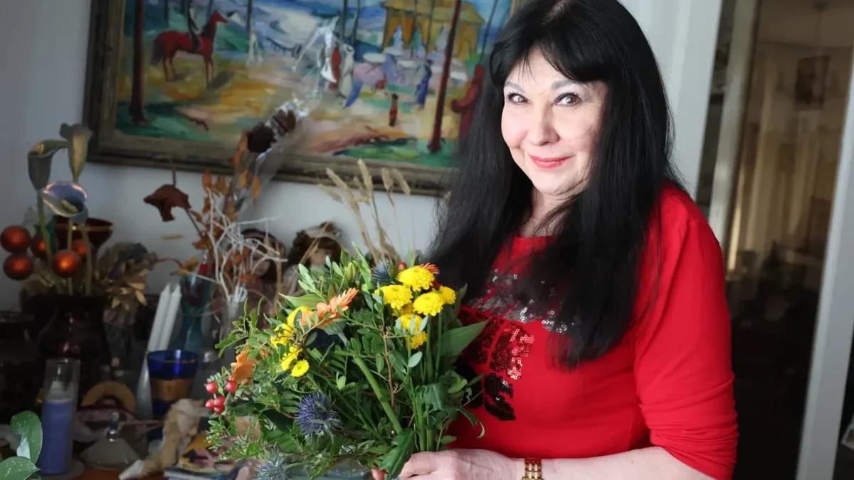 černovlasá žena s květinami v ruce