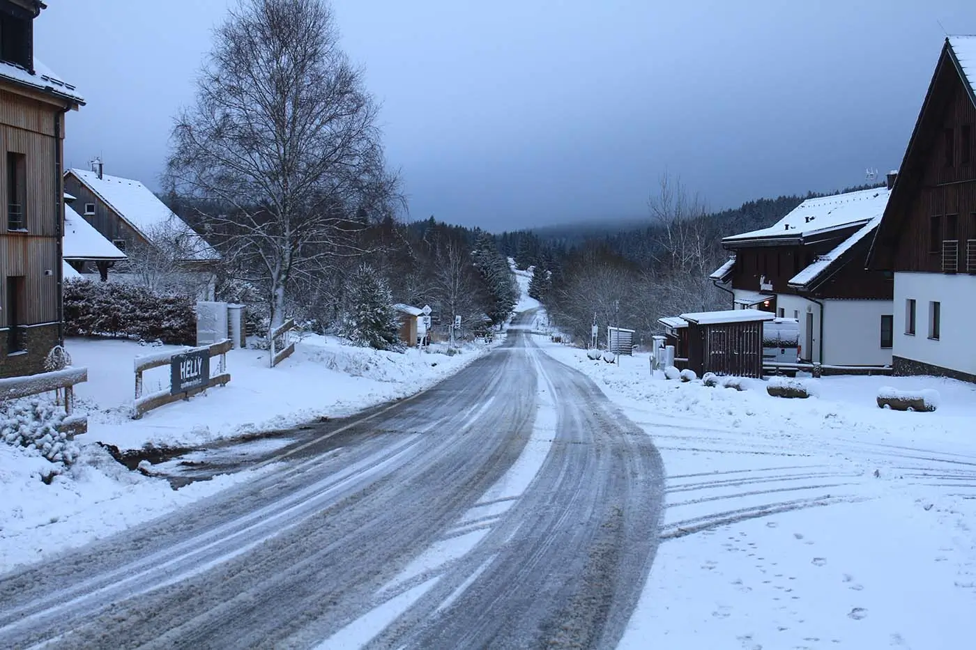 Zasněžená silnice ve vesnické oblasti v době stmívání