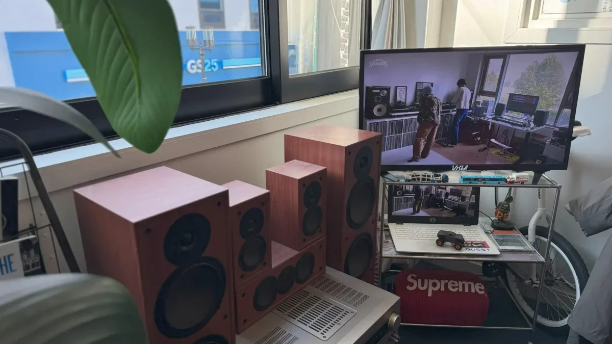 puštěná televize u okna vedle repráků