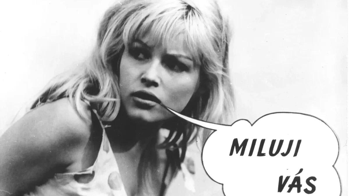 Black-and-white photo of a blonde woman with a speech bubble that says 'MILUJI VÁS'.