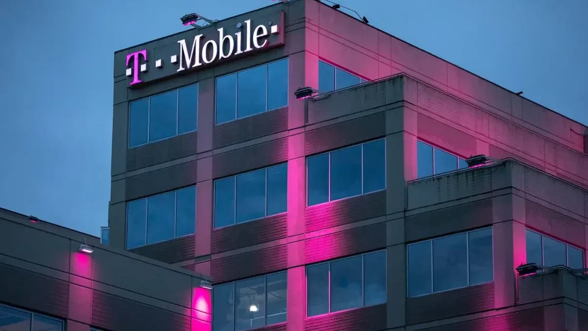 Růžově osvětlená budova mobilního operátora během večera