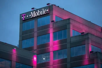 Růžově osvětlená budova mobilního operátora během večera