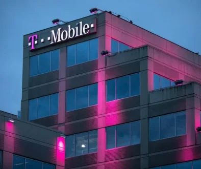 Růžově osvětlená budova mobilního operátora během večera