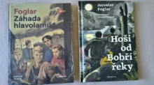Two vintage Czech adventure paperbacks laid on a surface; left cover shows a group of boys under a cloudy sky with the title Foglar Záhada hlavolamu, right cover titled Hoši od Bobří řeky with a moonlit jungle scene.