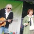 Žena s mikrofonem a muž s kytarou na podiu.