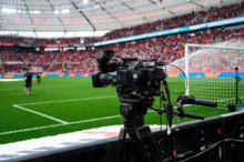 Kamera umístěná za brankou míří na fotbalové hřiště s hráči hrající fotbal