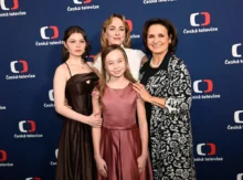 Four people in formal attire posing on a Česká televize backdrop.