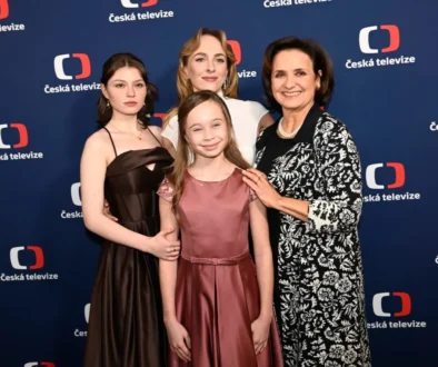 Four people in formal attire posing on a Česká televize backdrop.