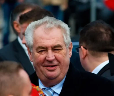 Starší muž se šedými vlasy a v obleku se usmívá