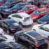 Venkovní plocha s několika desítkami různě barevných osobních automobilů
