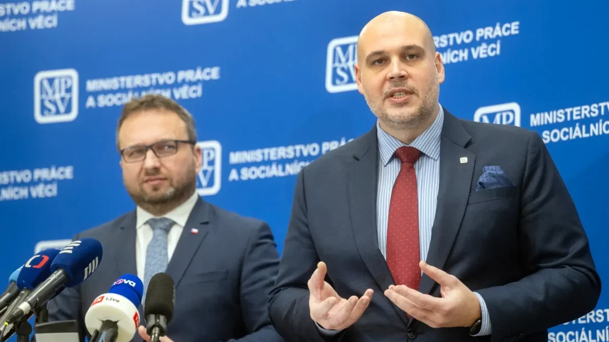 Dva muži v oblecích u moderátorského pultíku