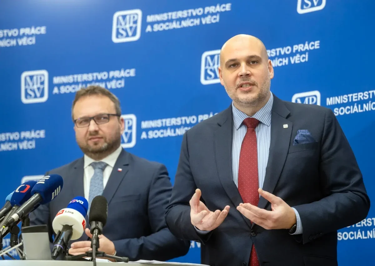 Dva muži v oblecích u moderátorského pultíku